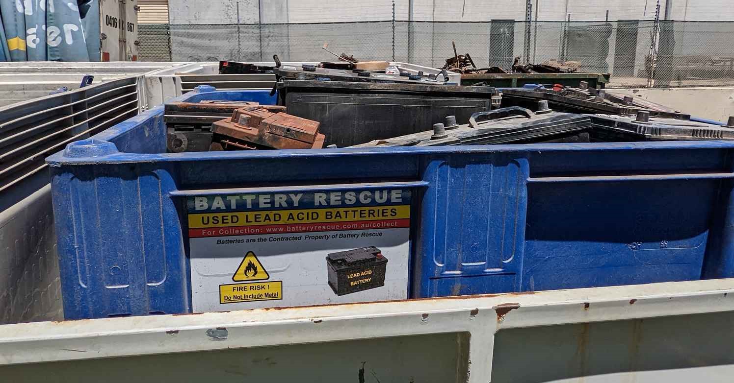 Batteries protruding above the sides of a plastic bin prevent its lid from being secured