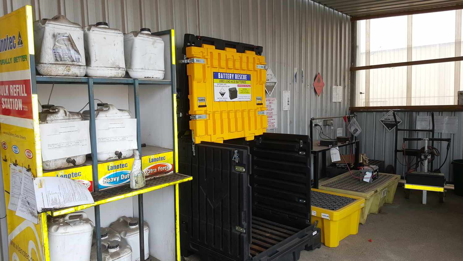 Used lead acid batteries stored in a Battery Rescue container at an automotive workshop